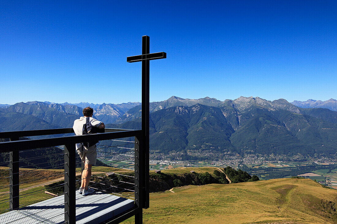 Man looking from chapel Santa Maria degli Angeli, (Architect: Mario Botta), Alpe Foppa, hike in the mountains to Monte Tamaro, Ticino, Switzerland