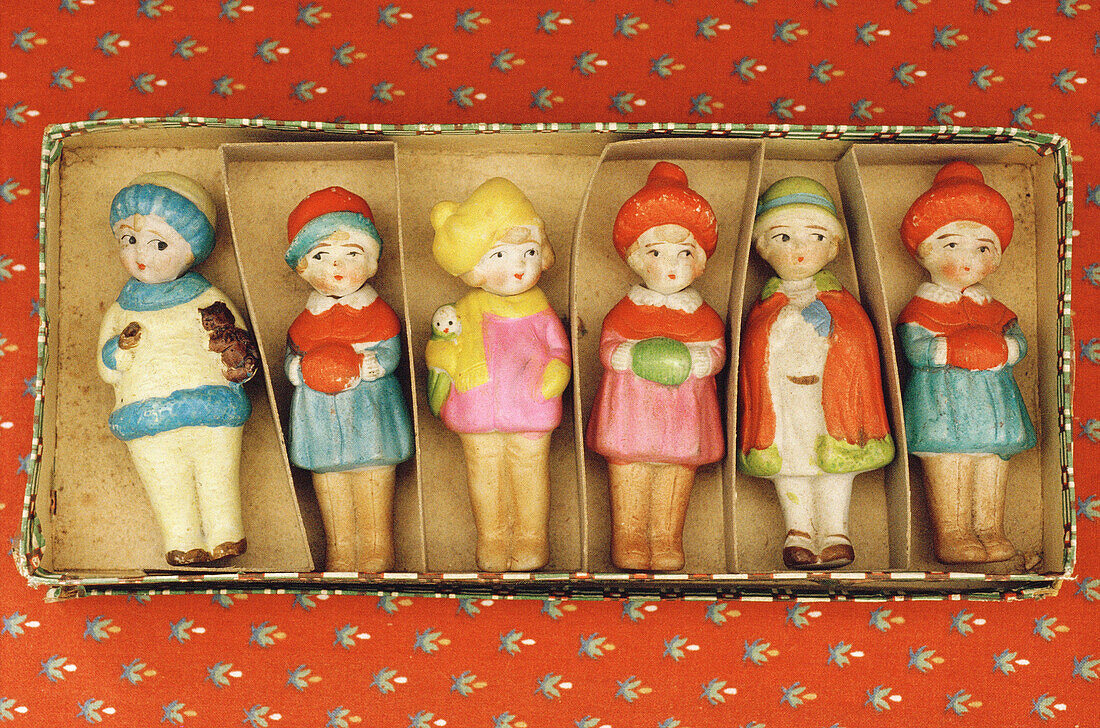 Handmade wooden figures in a cardboard box