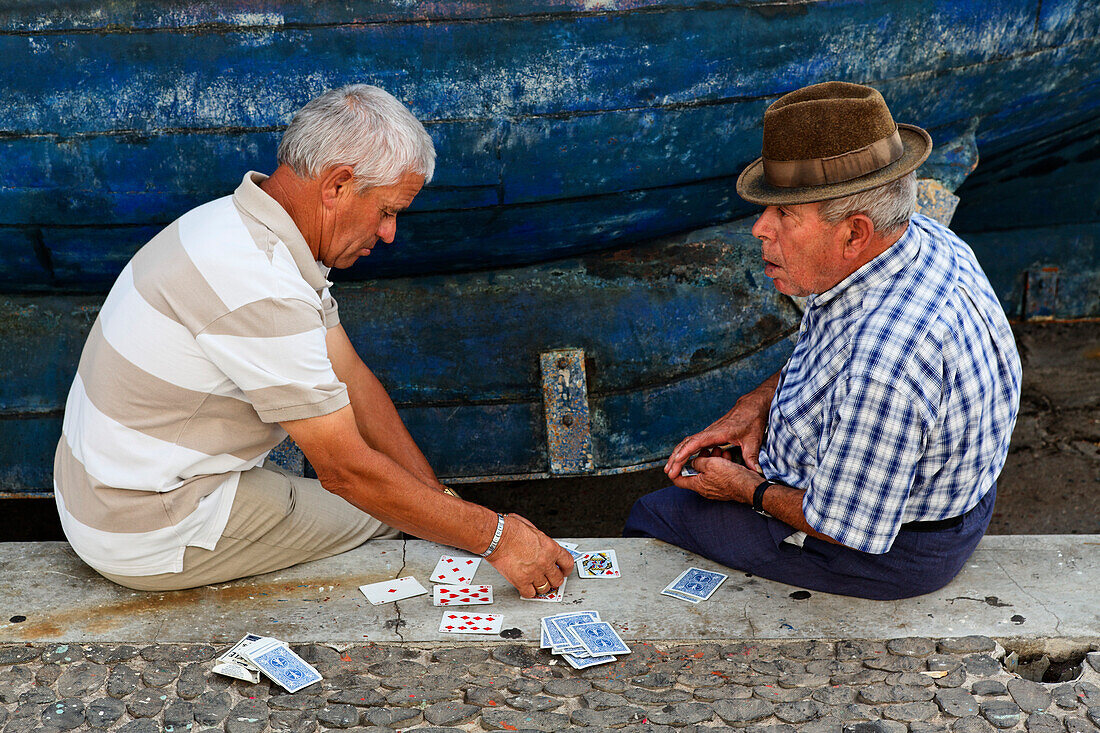 Männer beim Kartenspielen im Hafen von Camara de Lobos, Madeira, Portugal