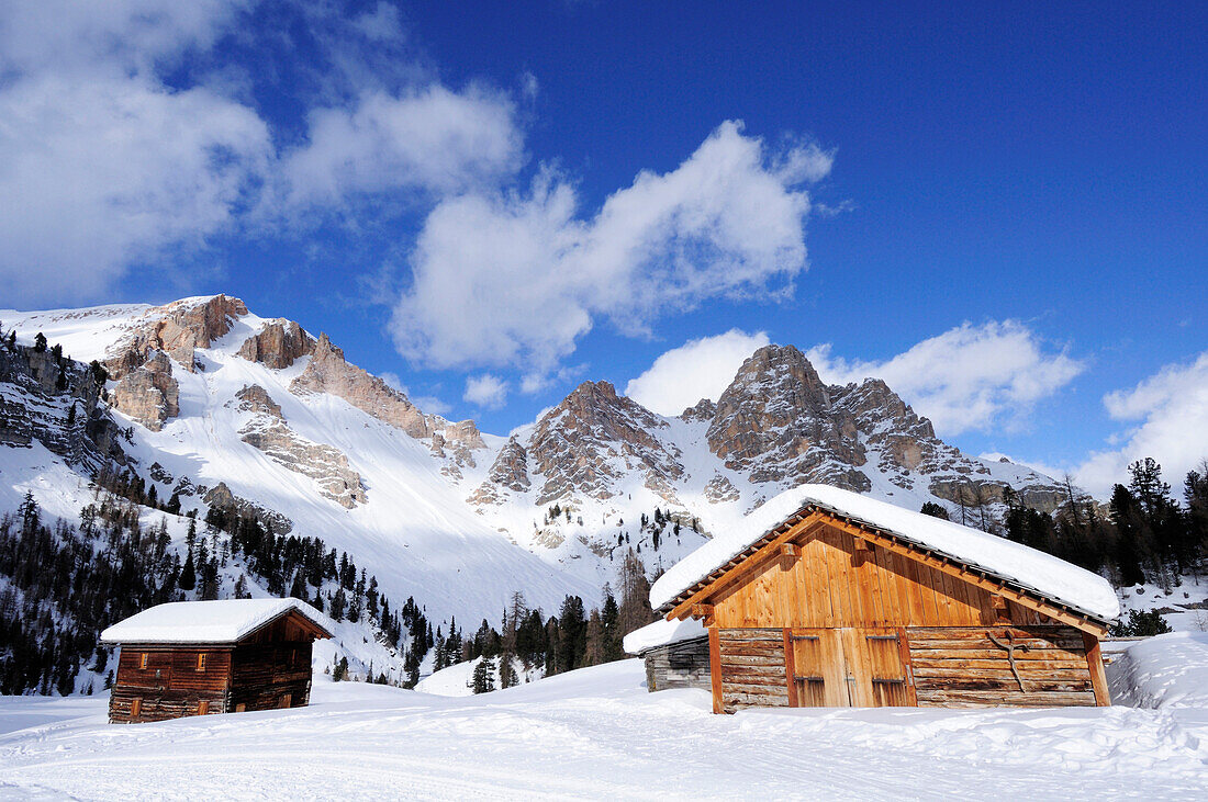 Verschneite Almgebäude mit Dolomitengipfel im Hintergrund, Naturpark Fanes-Sennes, UNESCO Weltkulturerbe, Dolomiten, Südtirol, Italien