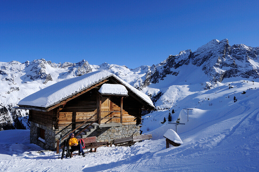 Frau auf Skitour macht vor Hütte Pause, Kasseler Hütte, Rieserfernergruppe, Südtirol, Italien