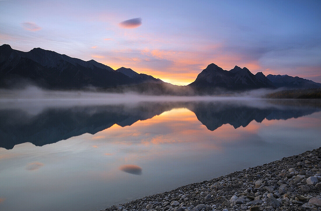 Sunrise skies and morning fog over Abraham Lake in autumn