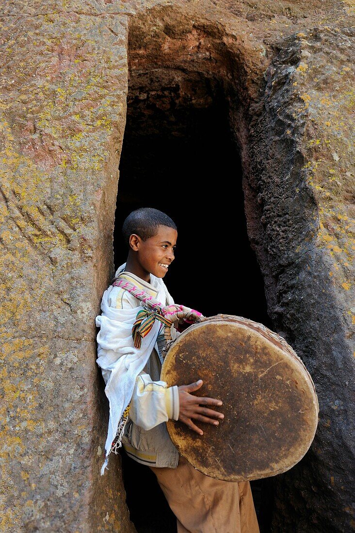 Ethiopia, Lalibela,Timkat festival, Church of Bieta Giyorgis, Young boy beating a drum to mark the return of the Tabots  Every year on january 19, Timkat marks the Ethiopian Orthodox celebration of the Epiphany  The festival reenacts the baptism of Jesus