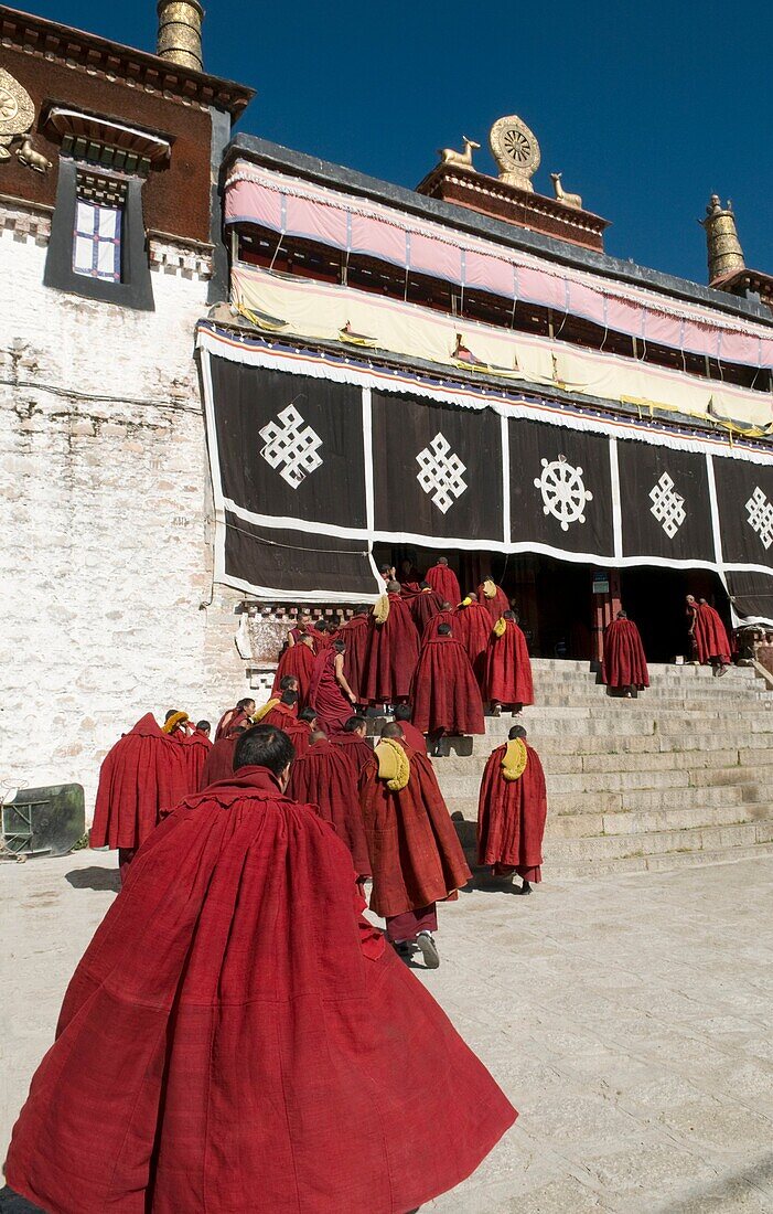 Red robed monks enter the Drepung Monastery Lhasa Tibet
