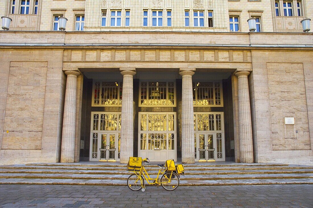 Postal bicycle in front of a building along Karl Marx Allee avenue in east Berlin Germany EU