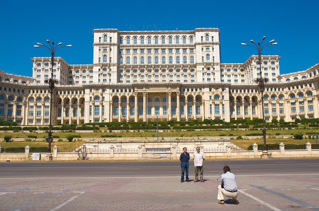 Tourists taking a photo in front of Palace of Parliament building in Bucharest Romania Europe