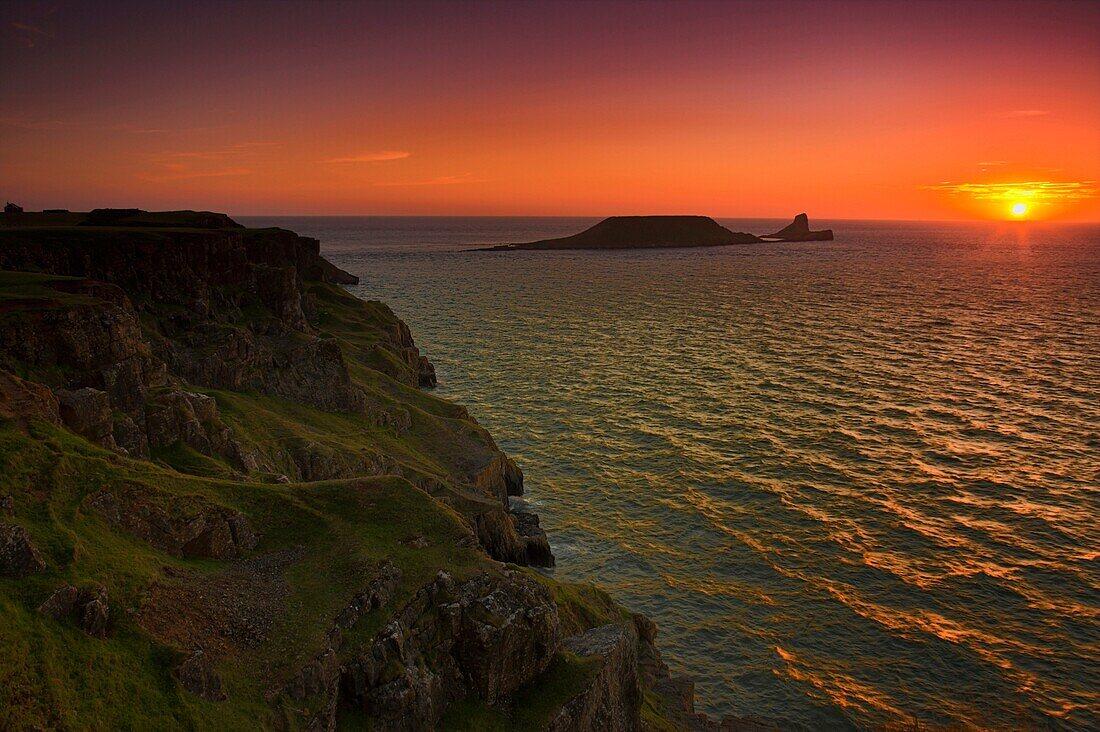 Sunset over Worms Head Rhossili Bay Gower Peninsula South Wales