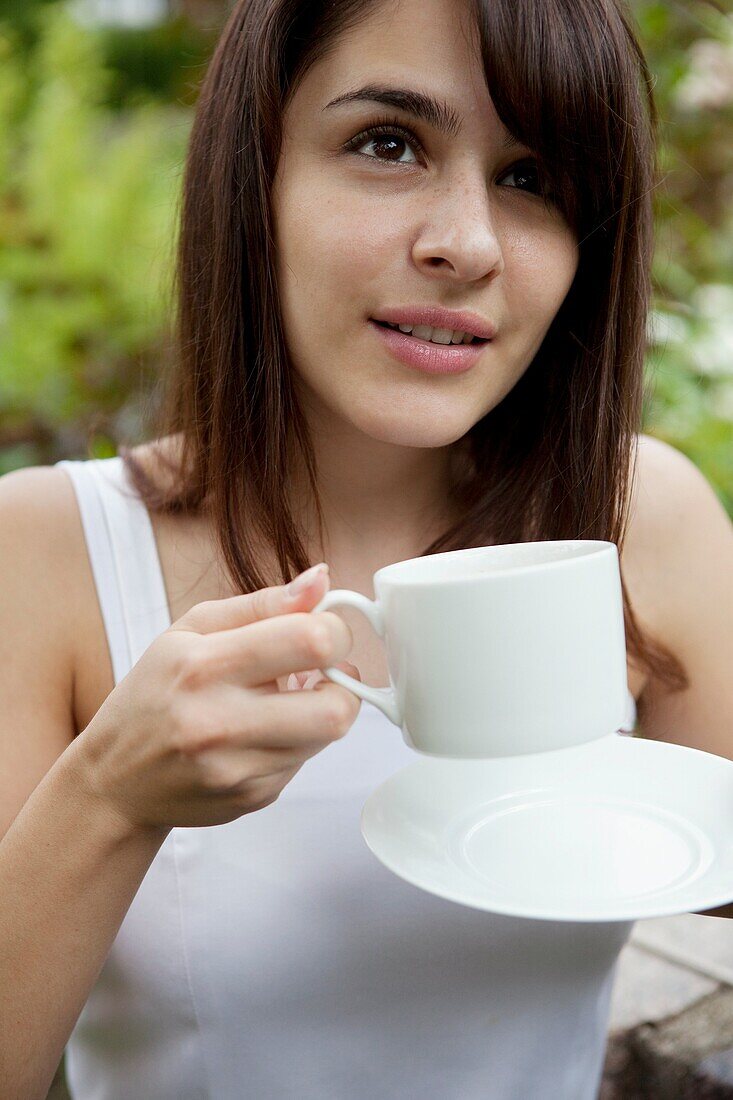 one young woman drinking coffee outdooe