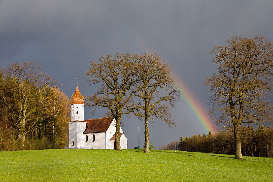 Kapelle mit Regenbogen im Alpenvorland, Oberbayern, Deutschland