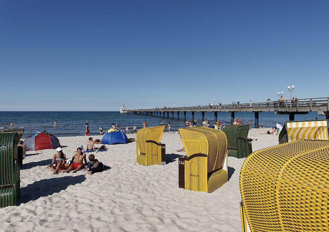 Menschen und Strandkörbe am Strand im Sonnenlicht, Ostseebad Binz, Rügen, Mecklenburg-Vorpommern, Deutschland, Europa