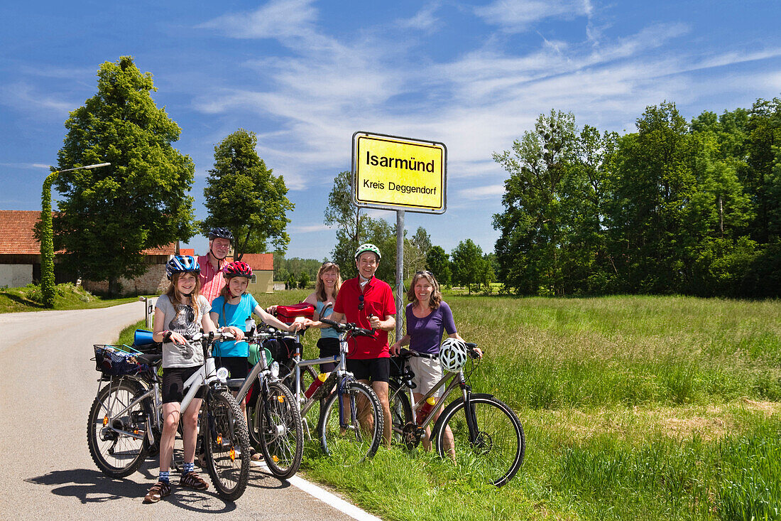 Cyclists beside a town sign, Isarmuend, Isar Cycle Route, Lower Bavaria, Germany