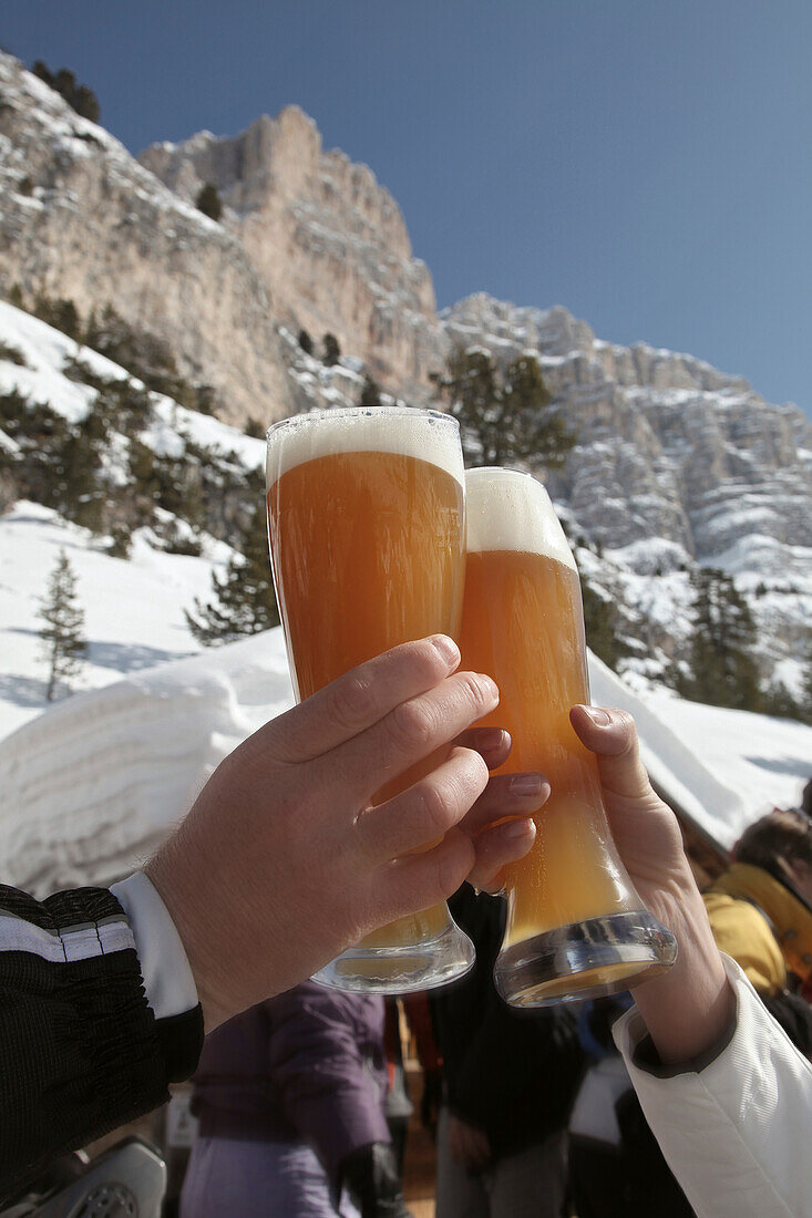 Zwei Personen stoßen mit Weißbier an, Alta Badia, Hochabtei, Dolomiten, Trentino-Südtirol, Italien