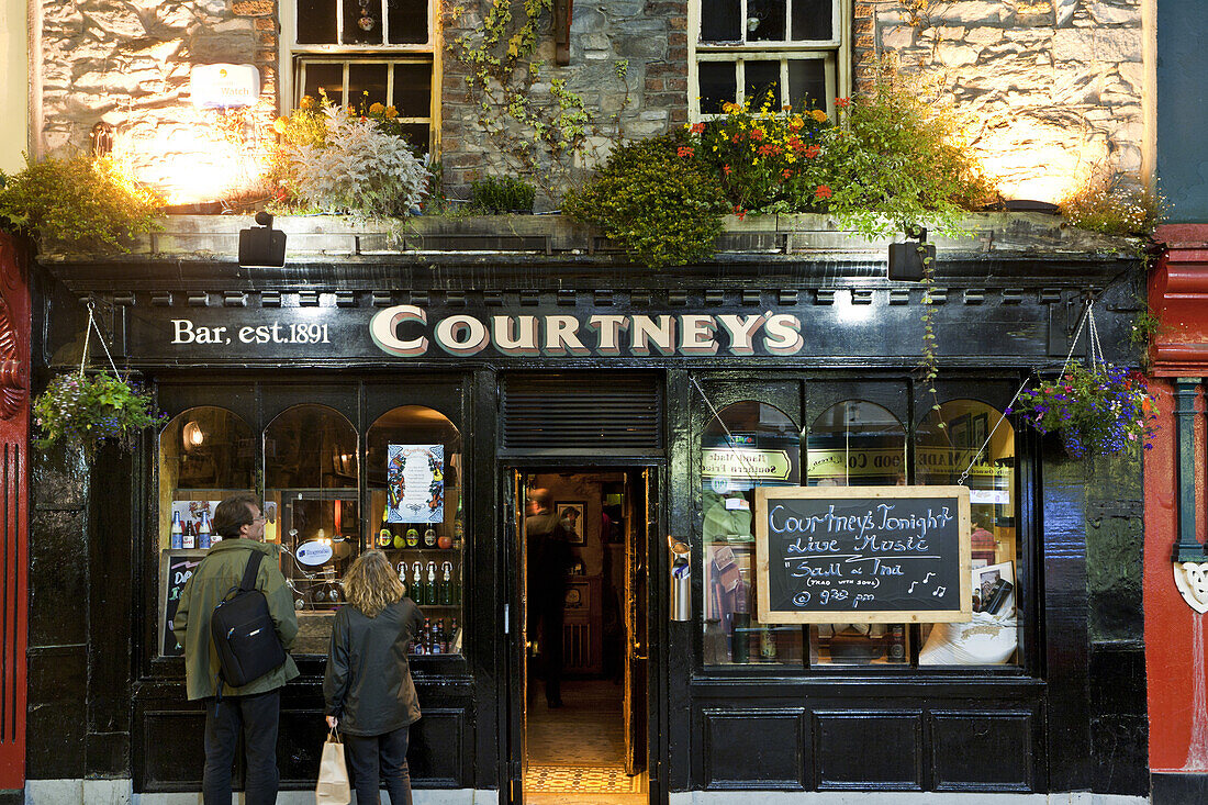 Couple in front of the entrance to the Courtney's Bar, Plunkett Street, Killarney, County Kerry, Ireland