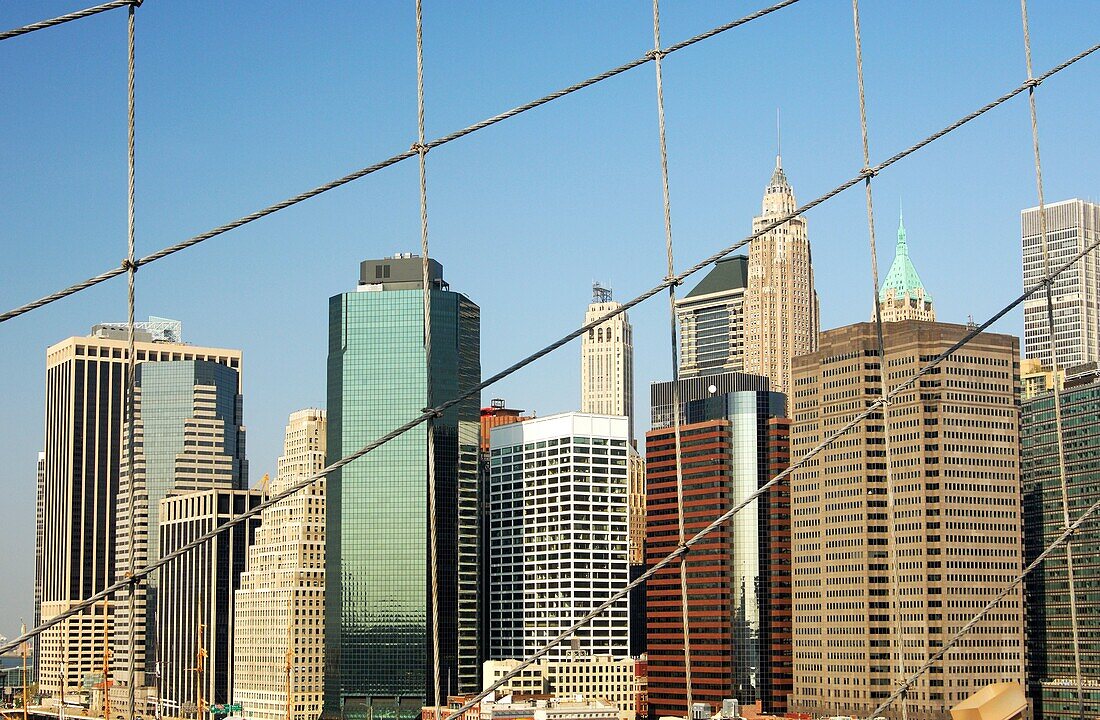 View through the tension ropes of the Brooklyn Bridge across the East River at skyscrapers at the FDR Drive, Financial District, Manhattan, New York, USA