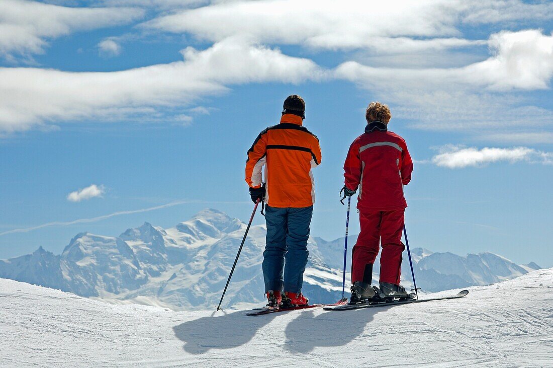 Two skiers lookign across the snow-covered French Alps towards the Mont Blanc peak, Morzine Avoriaz, Haute-Savoie, France