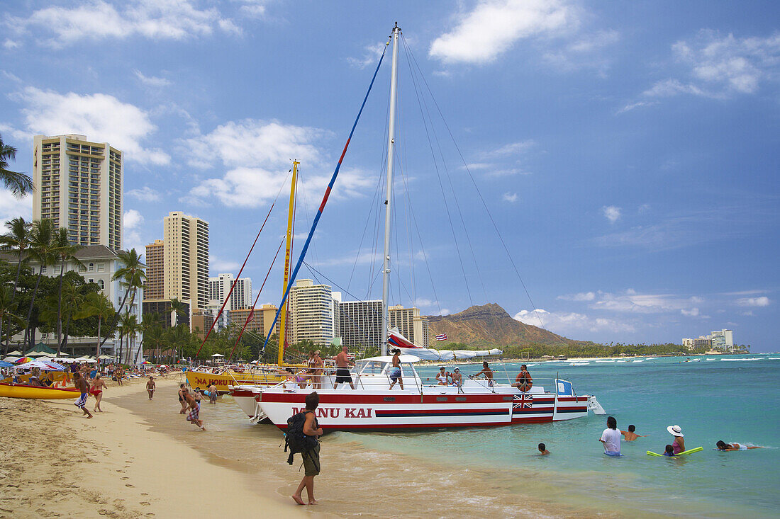 People, boat and catamaran at Waikiki Beach, Honolulu, Oahu, Island, Hawaii, USA, America