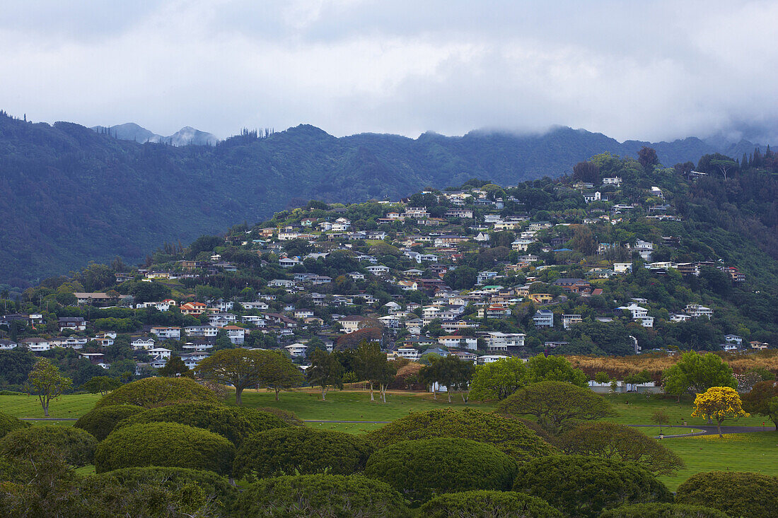 Houses on a mountain side in front of Punchbowl Crater, in the foreground National Memorial Cemetery of the Pacific, Honolulu, Oahu, Hawaii, USA, America
