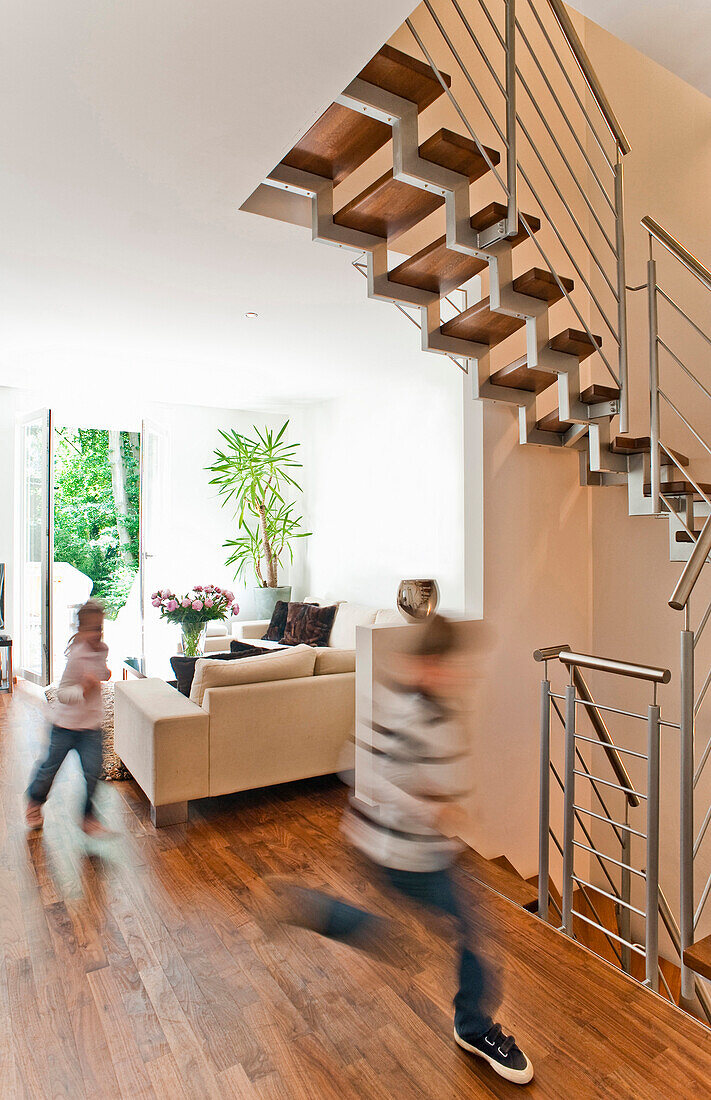 Two children running throuhg living area, Hamburg, Germany