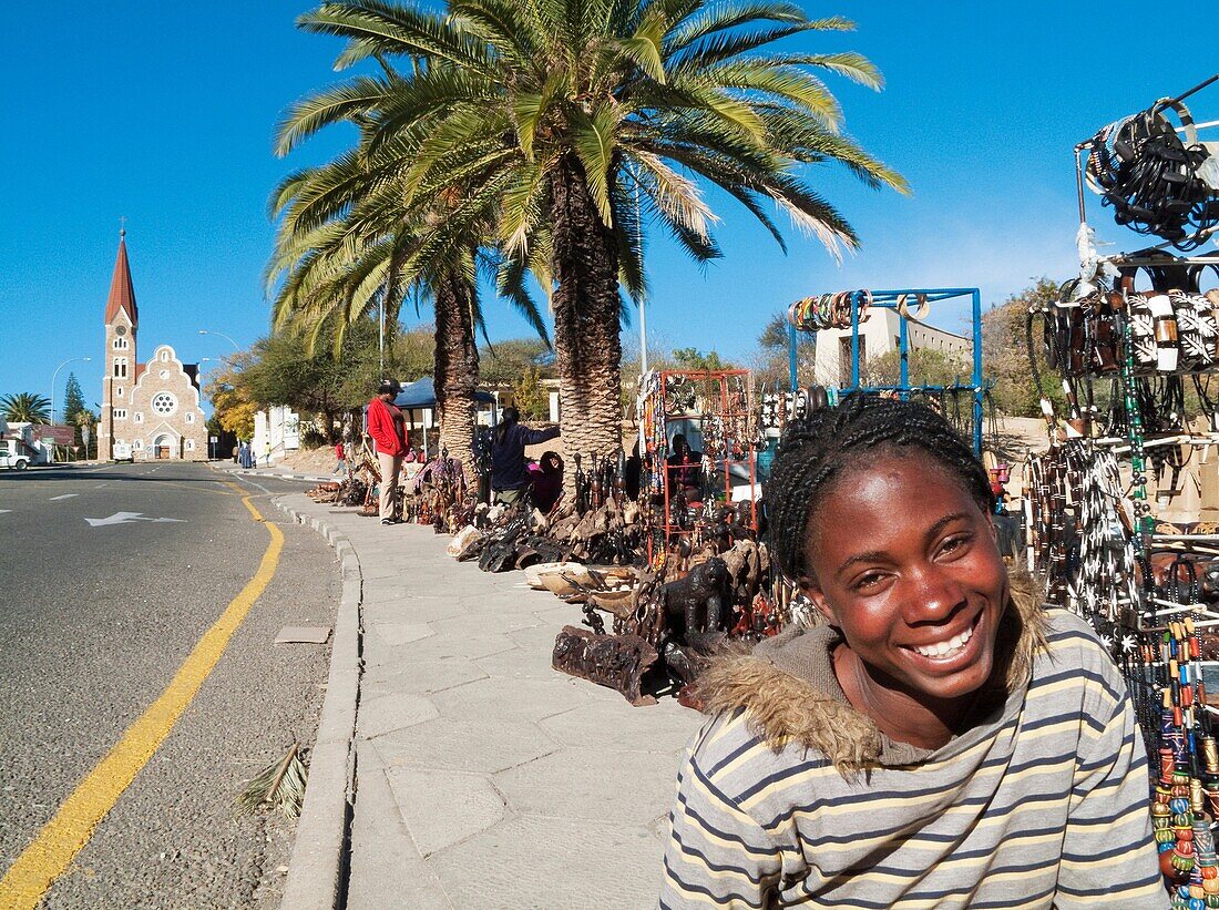 Namibia - Vendor at the well-known open-air souvenir market in the centre of Namibia's capital Windhoek with the famous Christuskirche Church of Christ in the background This Evangelical Lutheran Church was consecrated in 1910 and is one of the main land