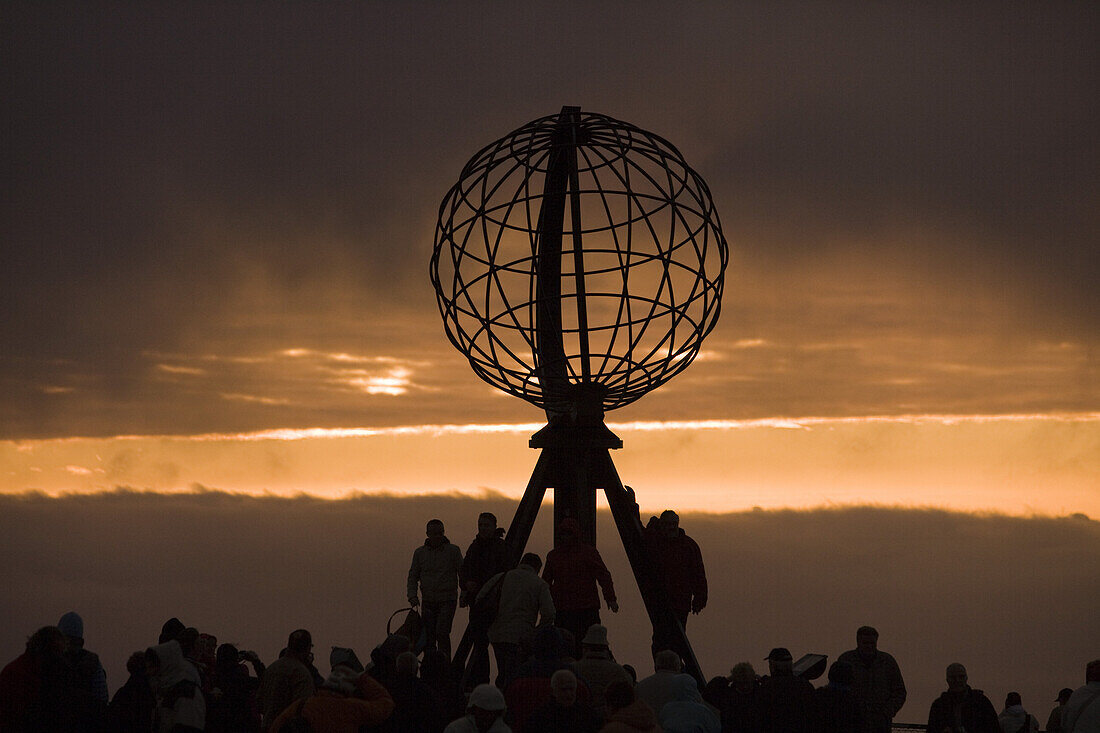 Menschen an der Skulptur der Weltkugel bei Mitternachtssonne, Nordkapp, Finnmark, Norwegen, Europa