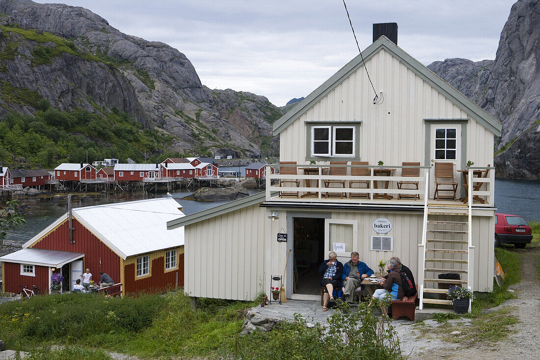 Menschen genießen Nachmittagskaffee vor Bäckerei, Nusfjord, Flakstadoy, Lofoten, Norwegen, Europa