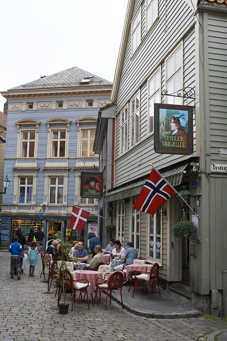 Menschen sitzen draußen vor Dyvekes Vinkjeller Restaurant und Café Christian II, Bergen, Hordaland, Norwegen, Europa