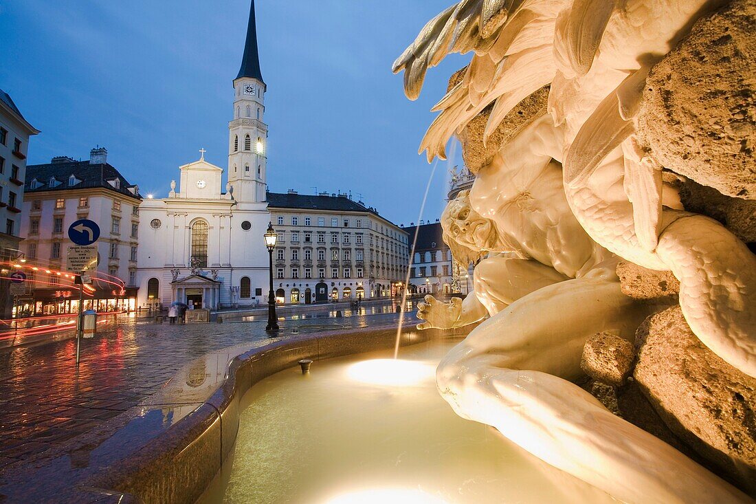 Fountain in front of Hofburg Imperial Palace with Michaelerkirche in background, Michaelerplatz, Vienna, Austria