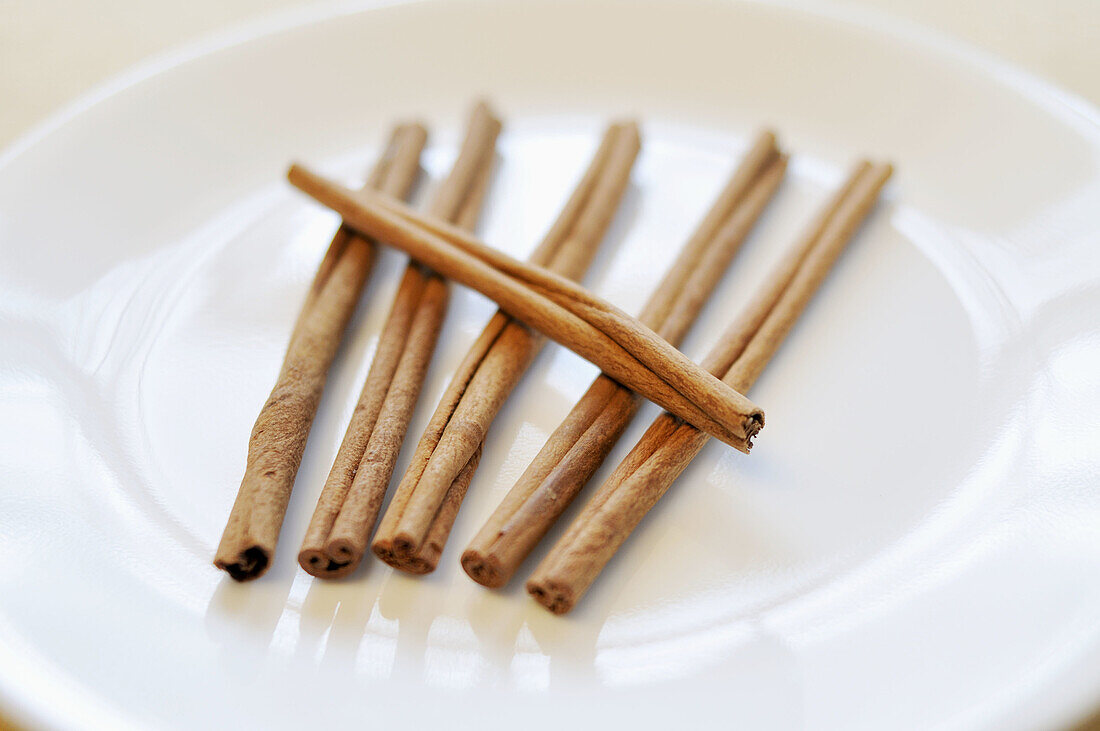 6 cinnamon sticks on white plate