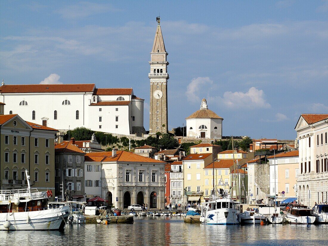Boats in the marina in the coastal town of Piran in southern Slovenia with the Church of St George above
