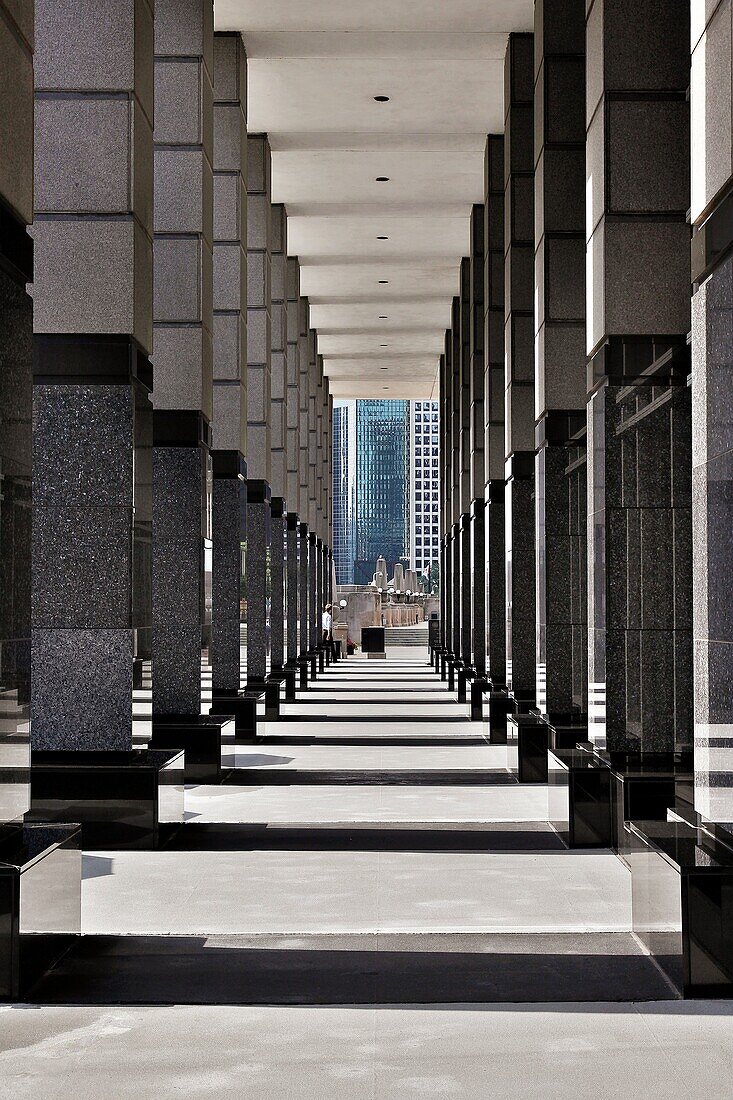 Businessman walking past columns of modern office area