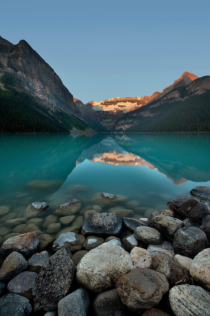 Lake Louise with foreground rocks just after sunrise