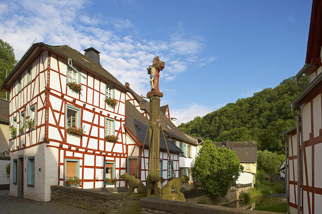 Löwendenkmal mit Kreuz auf Bogenbrücke über die Elz, Fachwerkhaus, Monreal, Eifel, Rheinland-Pfalz, Deutschland, Europa