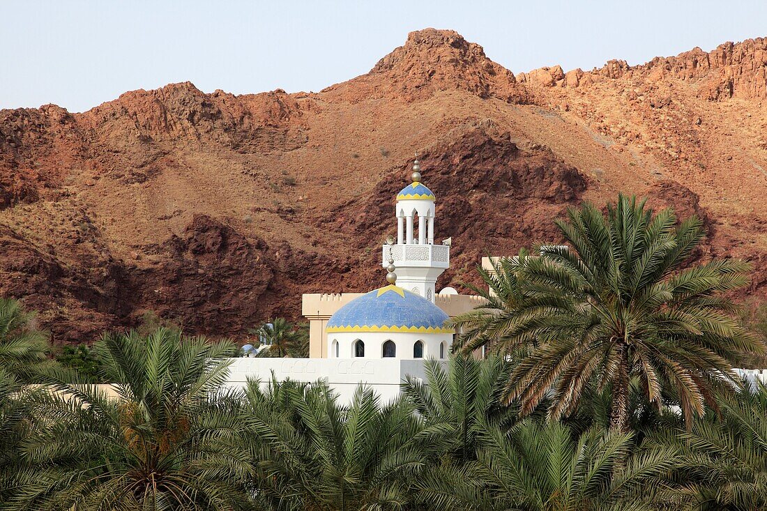 colorful mosque in wadi with date palms at the village of Fanja, Hajar al Gharbi, Sultanate of Oman, Asia.