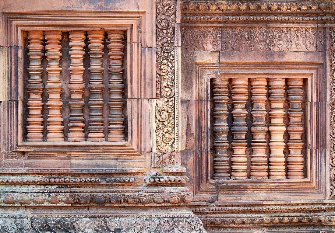 Cambodia - Blind windows with colonettes at the temple of Banteay Srei, which is known for the exquisite exuberance of its sandstone carvings Banteay Srei is located about 25km northeast of the main group of temples in Angkor The temple complexes of Ang