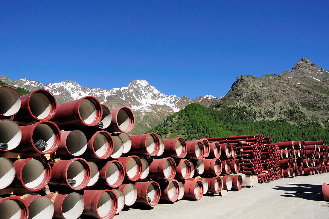 Construction site with pipes in front of mountains, Schnalstal valley, Oetztal mountain range, South Tyrol, Italy