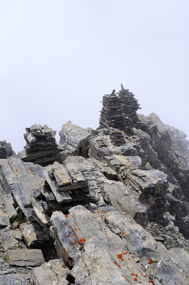 Several cairns at the summit of Igl Compass, Albula pass, Albula mountain range, Engadin, Grisons, Switzerland