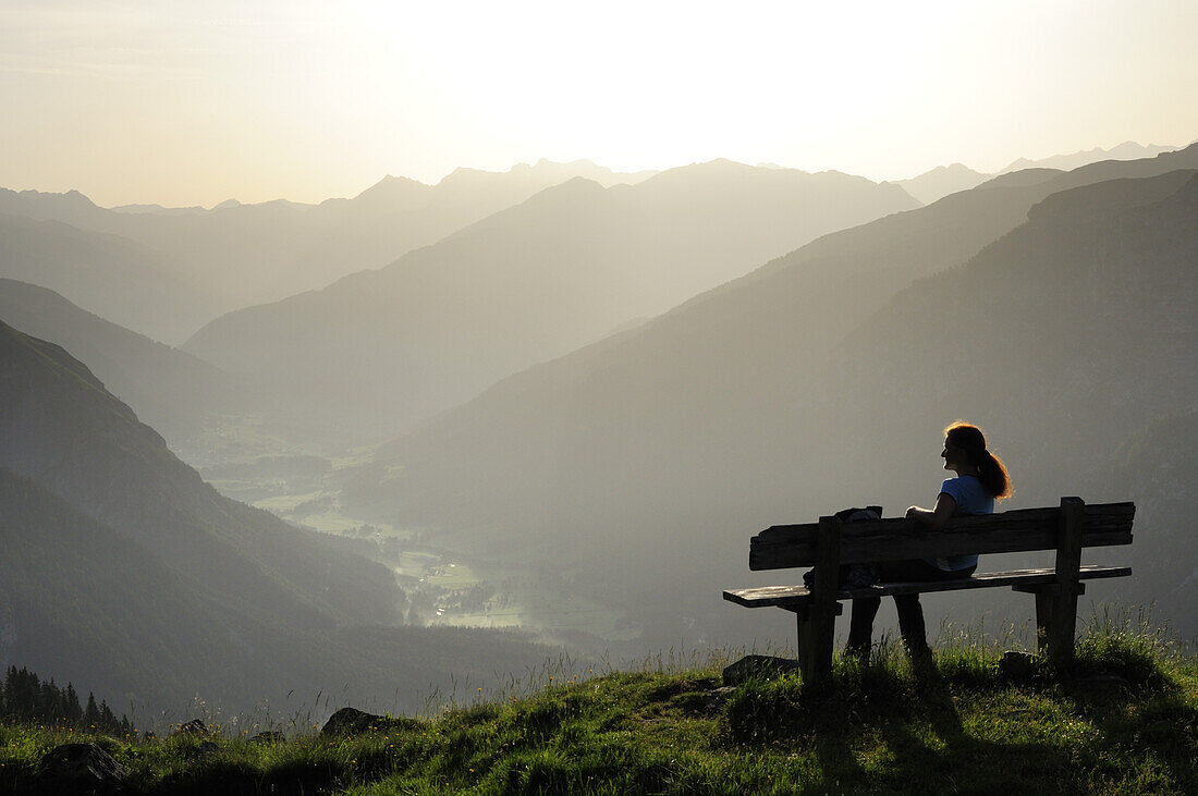 Frau sitzt auf einer Bank und genießt Aussicht auf Gschnitztal, Habicht, Gschnitztal, Stubaier Alpen, Tirol, Österreich