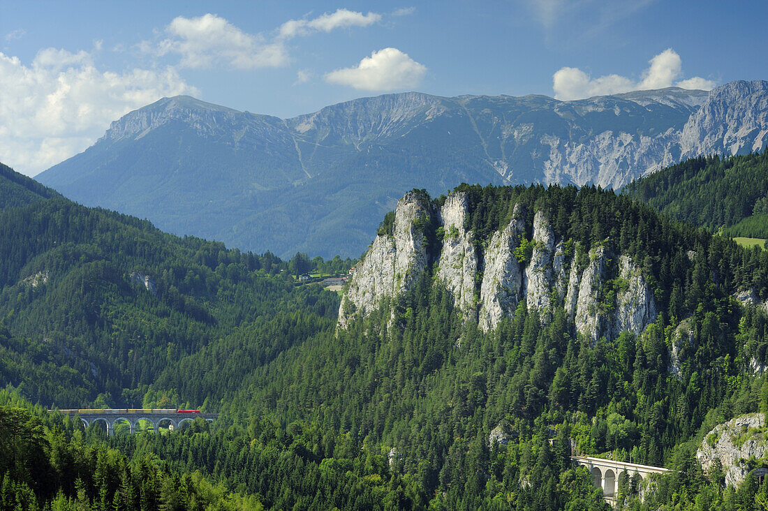 Zug fährt über Kalte Rinn-Viadukt, Rax im Hintergrund, Semmeringbahn, UNESCO Weltkulturerbe Semmeringbahn, Niederösterreich, Österreich