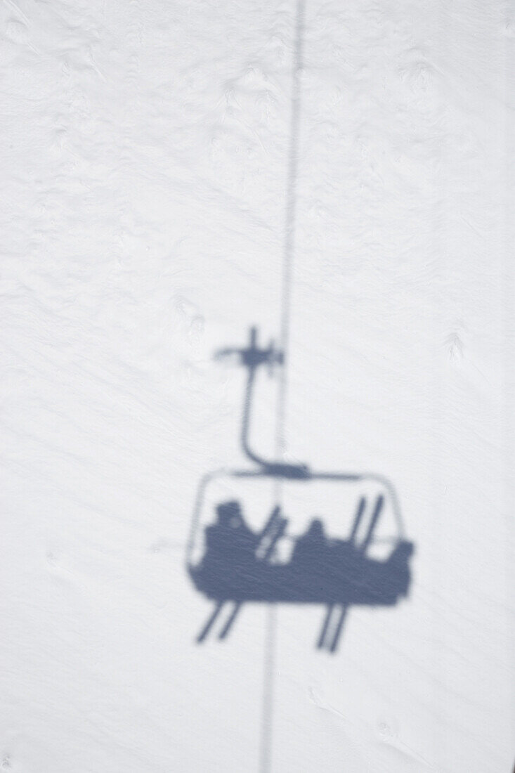 Schatten von Sessellift mit Skifahrern, Disentis, Oberalppass, Kanton Graubünden, Schweiz