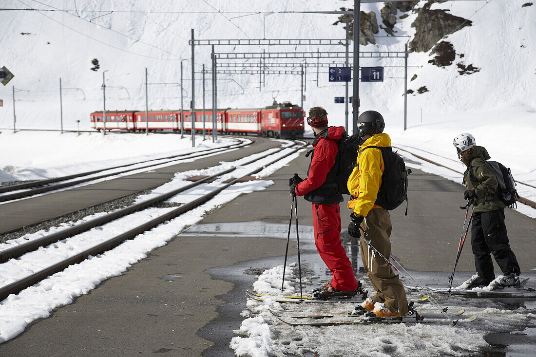 Skifahrer warten auf Zug, Disentis, Oberalppass, Kanton Graubünden, Schweiz