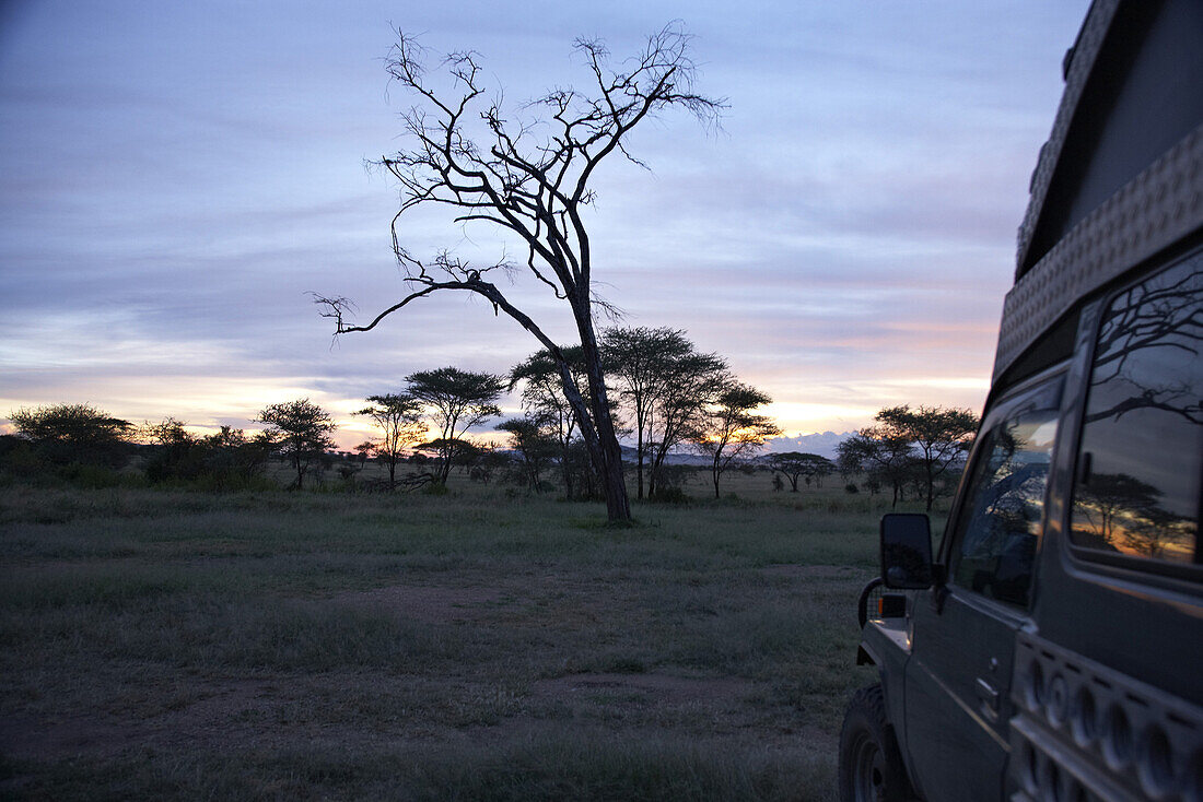 Toyota Landcruiser in der Steppe bei Sonnenuntergang, Serengeti, Tansania, Afrika