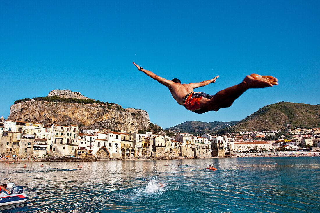 Man jumping in the sea, Cefalú, Palermo, Sicily, Italy