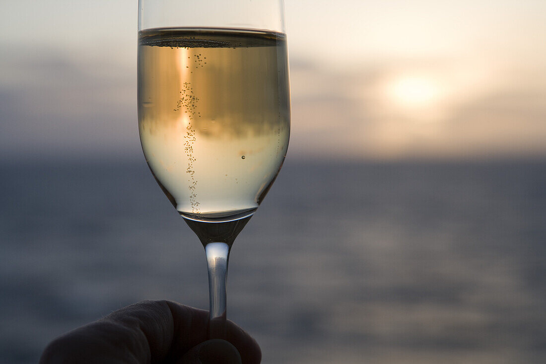 Glas mit Champagner an Bord von Kreuzfahrtschiff Silver Spirit bei Sonnenuntergang, Atlantik, Europa
