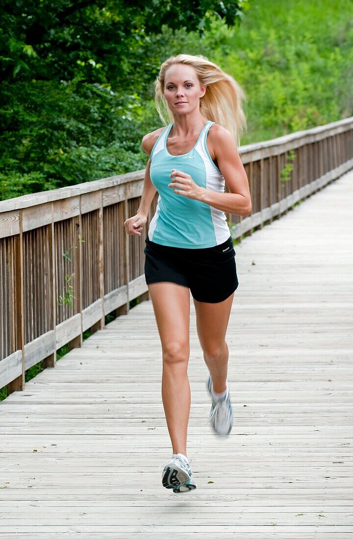 30 year old blonde woman jogging in work out clothes