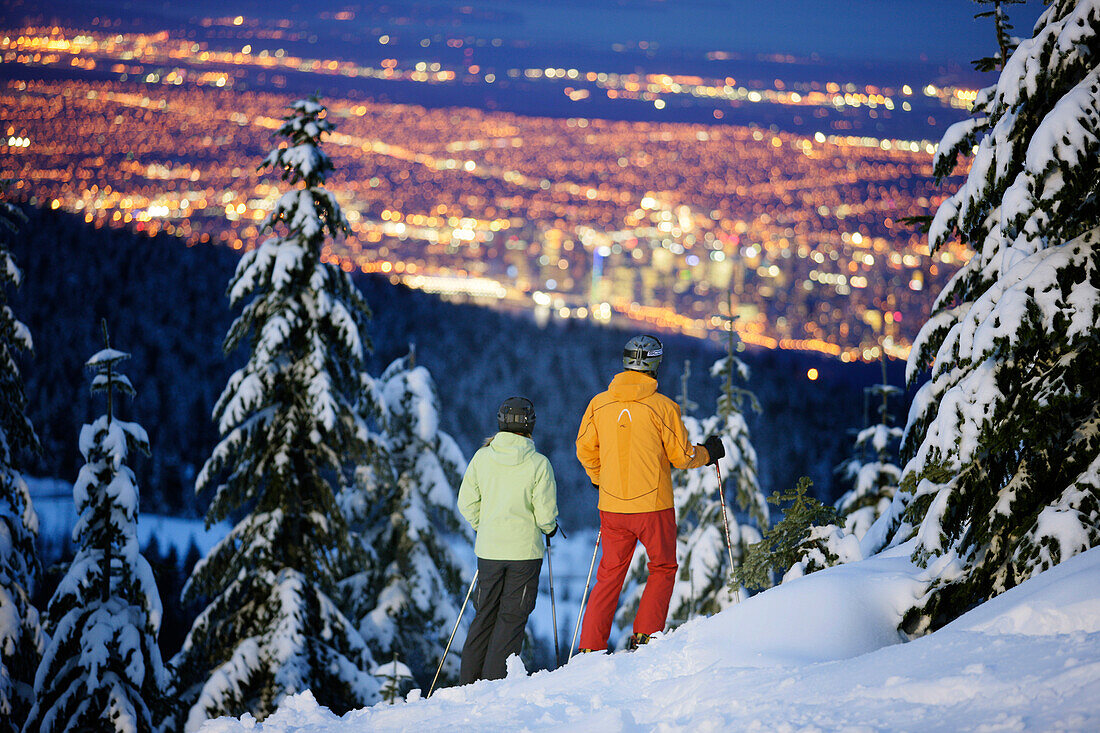 Skifahrer blicken auf Vancouver am Abend, British Columbia, Kanada