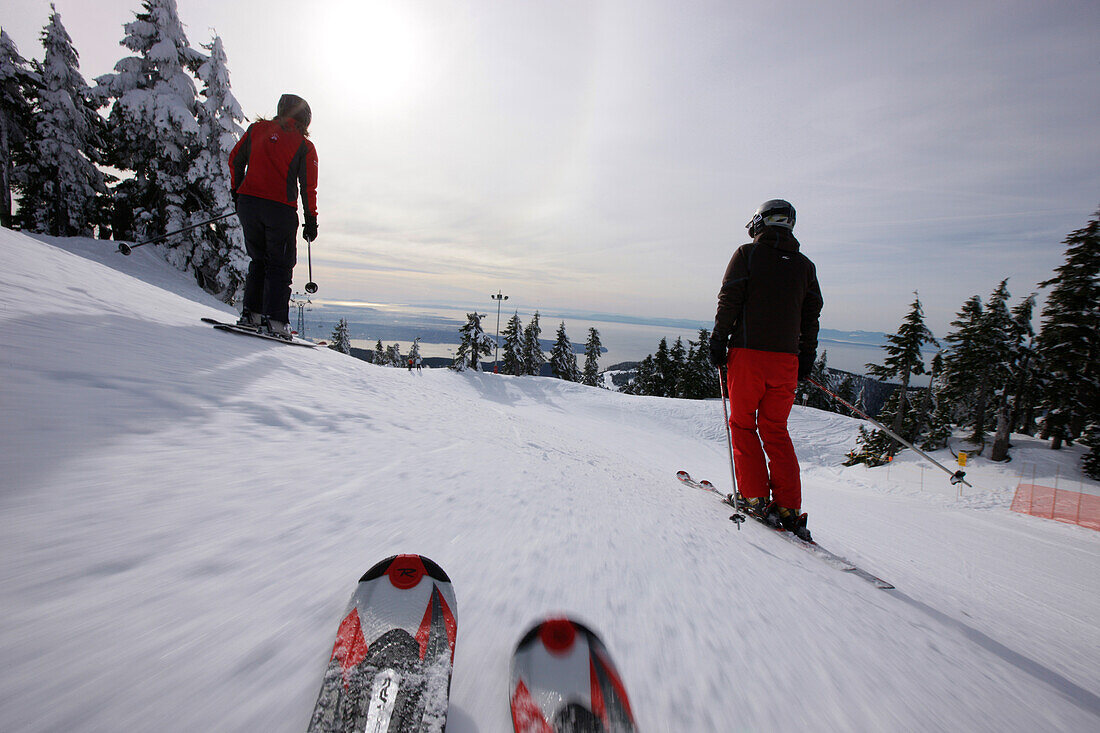 Skiers on Glades Run, Pacific and Vancouver Island in background, Cypress Mountain, British Columbia, Canada
