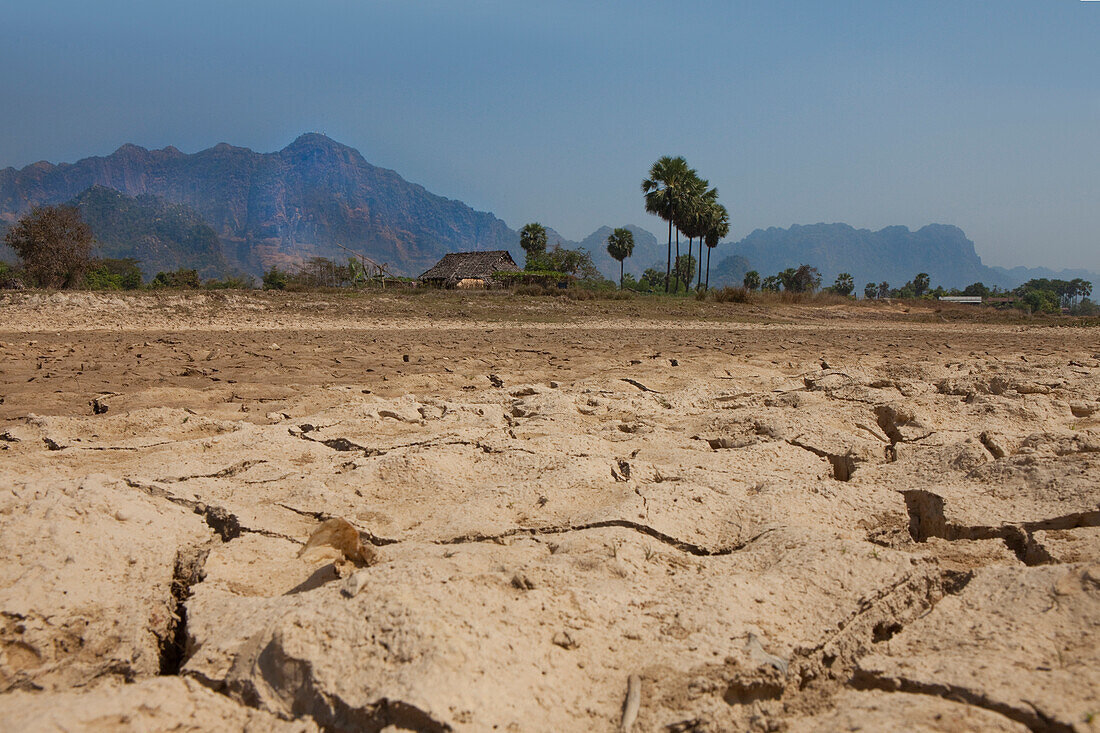 Hut on dry clay soil, karst mountains in the background, Kayin State, Myanmar, Birma, Asia