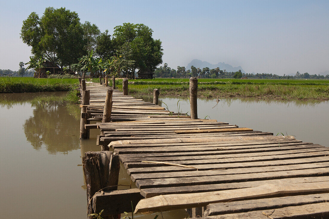 Holzsteg als Brücke vor Hütte mit Feldern, Kayin Staat, Myanmar, Burma, Asien