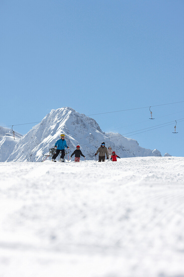 Familie fährt Ski, Schlößlelift, Blick auf Bärenkopf, Hirschegg, Kleinwalsertal, Vorarlberg, Österreich