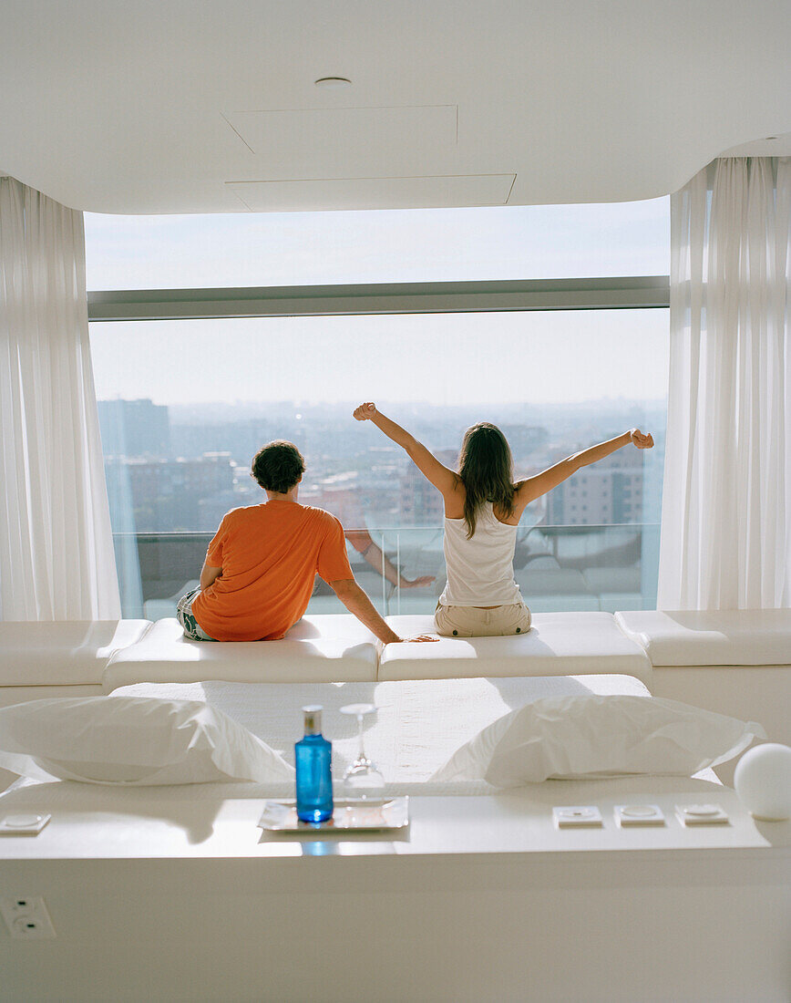 Couple enjoying view out of a hotel room, Madrid, Spain